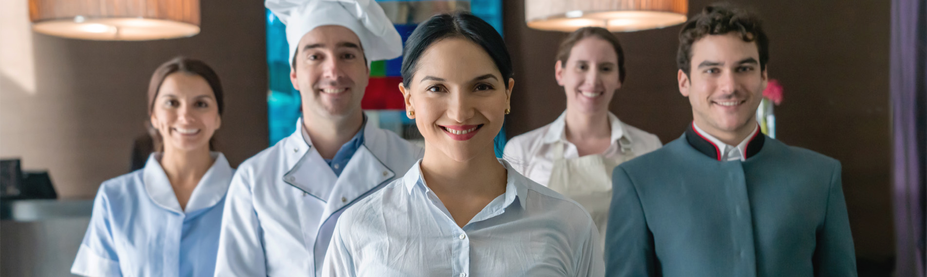 A Multicultural team of hotel staff workers looking at camera, smiling