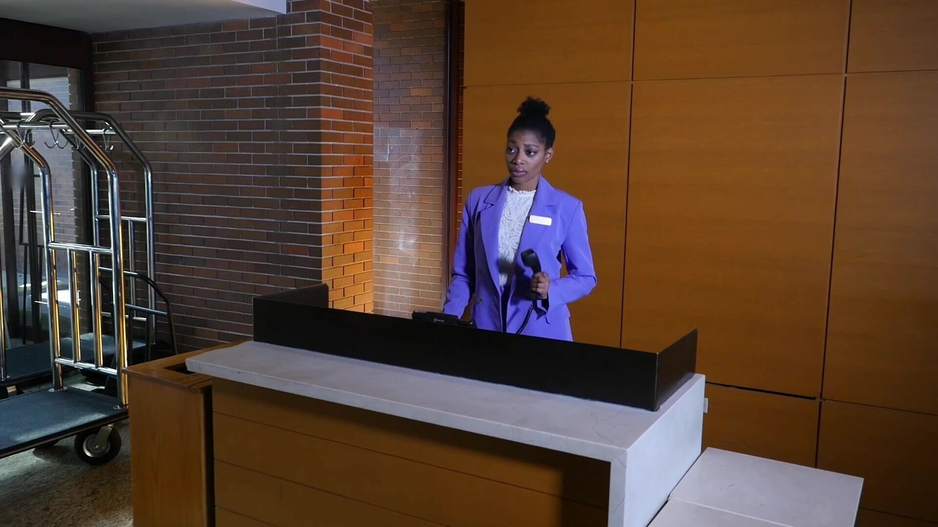 Hospitality employee answers phone at front desk    